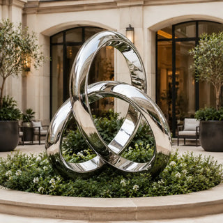 Interlocking ring stainless steel sculpture with three mirror polished loops for modern outdoor landscapes