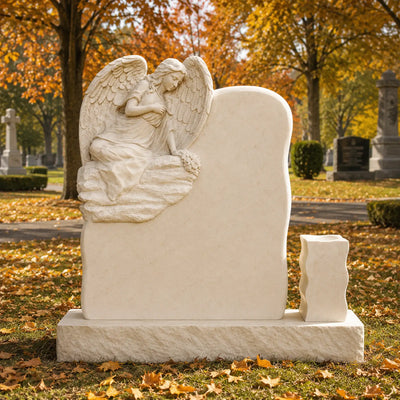 Marble angel memorial with carved flower bouquet, detailed wings and warm beige natural stone craftsmanship