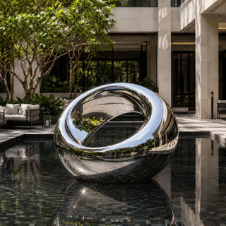 Outdoor stainless steel orb sculpture designed as a reflective centerpiece for contemporary gardens