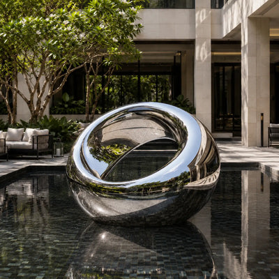Outdoor stainless steel orb sculpture designed as a reflective centerpiece for contemporary gardens