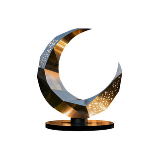 Stainless steel moon statue installed in an outdoor plaza with contemporary architectural surroundings.
